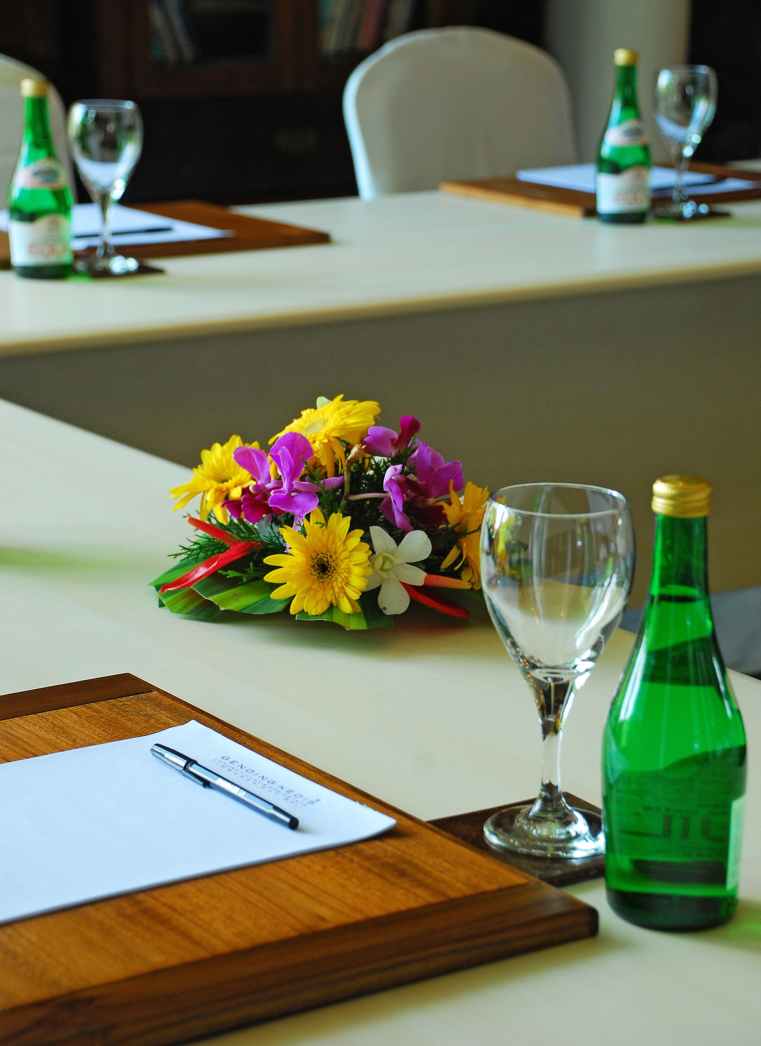 A table with a bouquet of flowers, a wine glass, and a bottle of champagne.