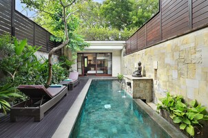 Una piscina al aire libre, sombrillas, sillones reclinables de piscina