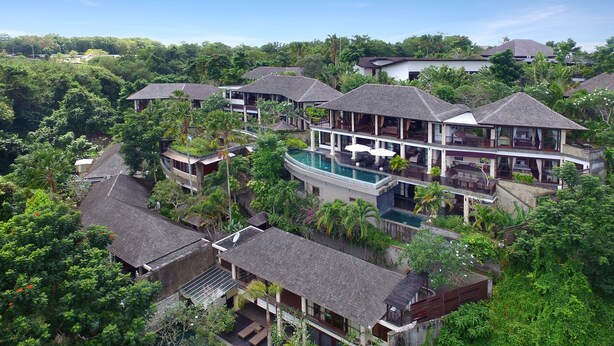Ein Resort mit mehreren Gebäuden, einem Pool und üppiger Bepflanzung.