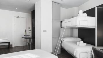 A modern hotel room with a bunk bed, a desk, and a chair.