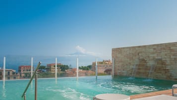 Relax by the pool surrounded by a mountainous landscape and Mediterranean-style architecture.