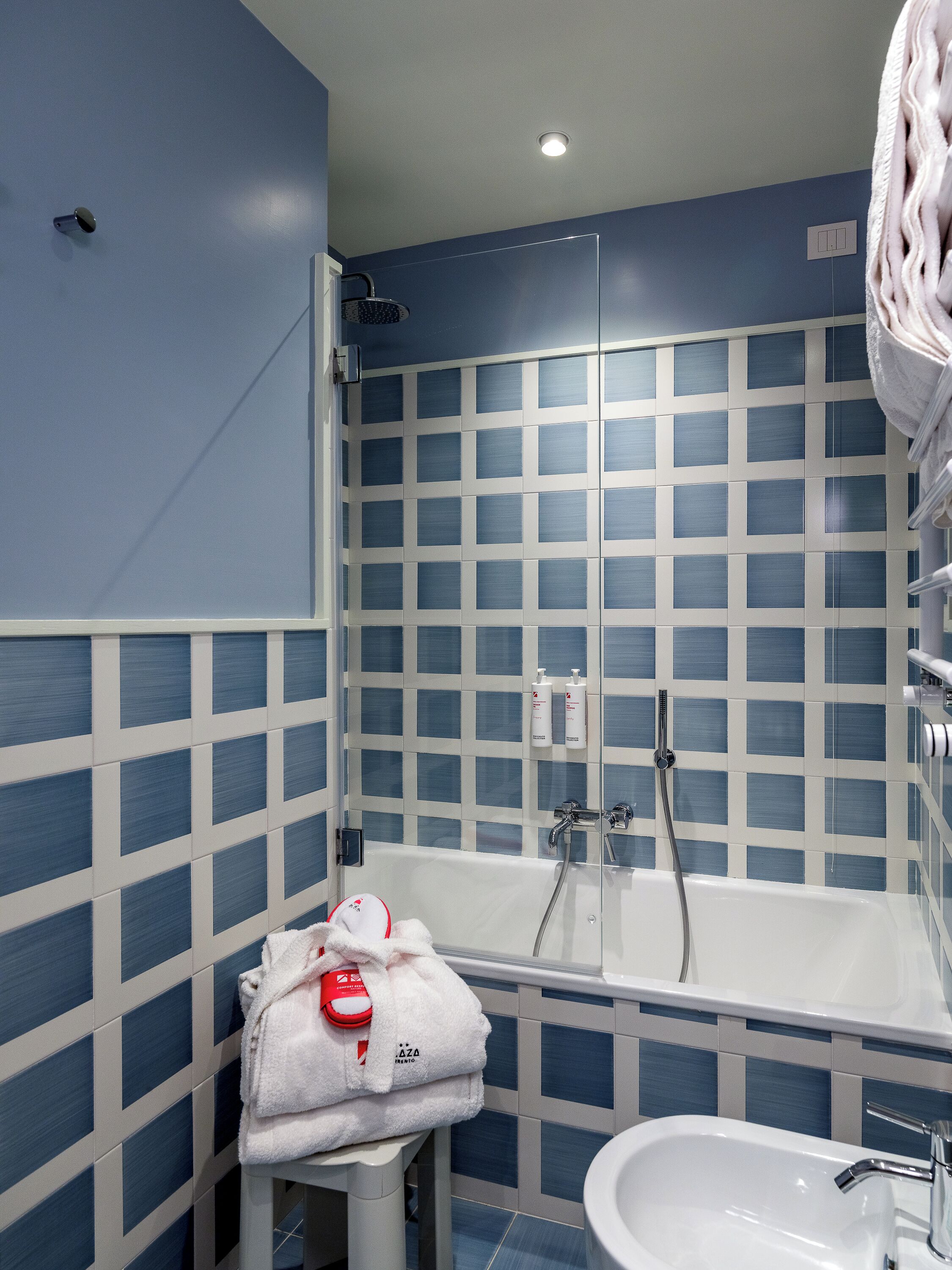 A bathroom with a bathtub, a sink, and a towel rack.