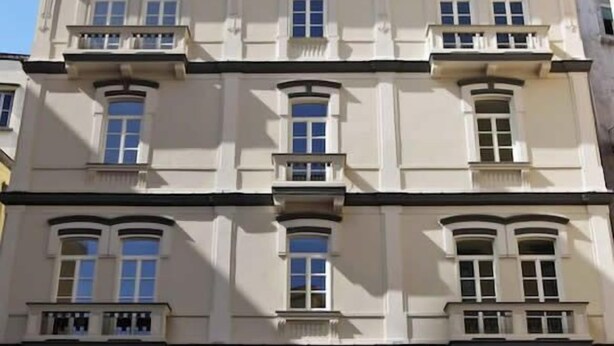 A multi-story building with a symmetrical facade, featuring evenly spaced windows and balconies on each floor. - Albergo Palazzo Decumani (Naples)