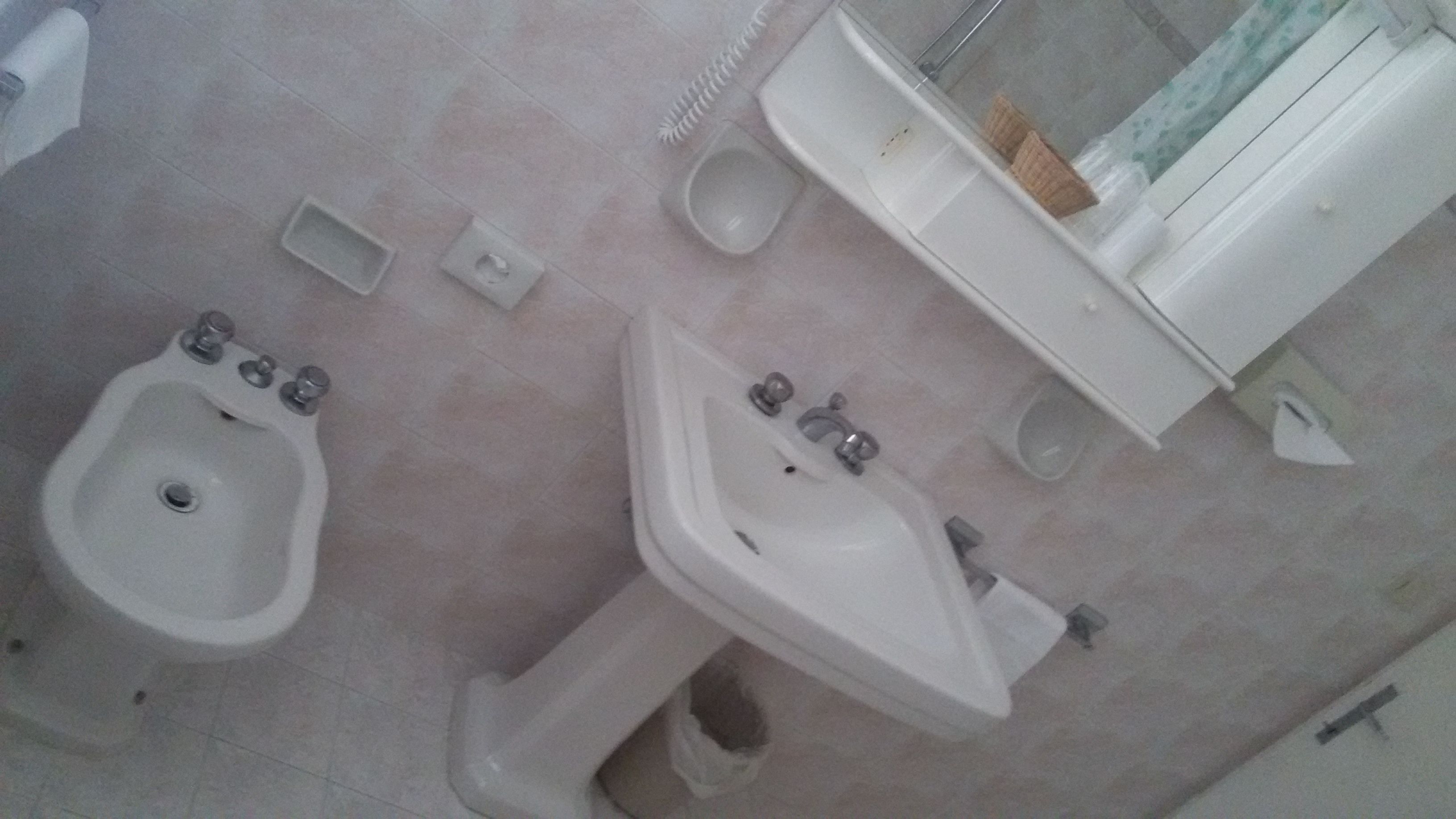 A bathroom with a bidet, a sink, and a toilet.