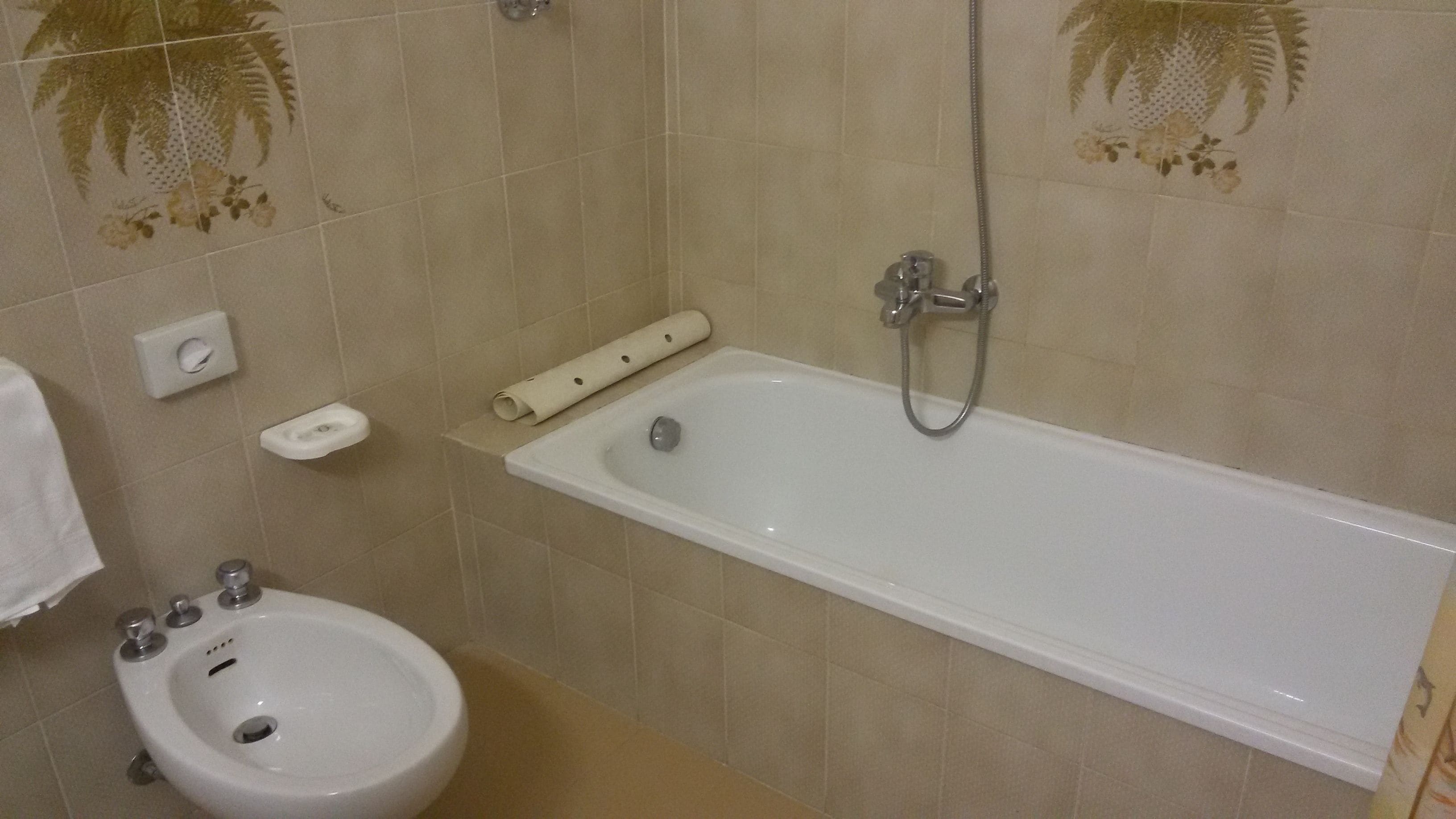 A bathroom with a bathtub, a bidet, and a toilet.