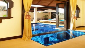 A room with a view of a pool area, featuring a glass door and yellow curtains. - Chada Lanta Beach Resort  (Ko Lanta)