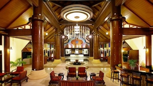 A spacious lobby with high wooden beams, a central fountain, and seating areas. - Chada Lanta Beach Resort  (Ko Lanta)