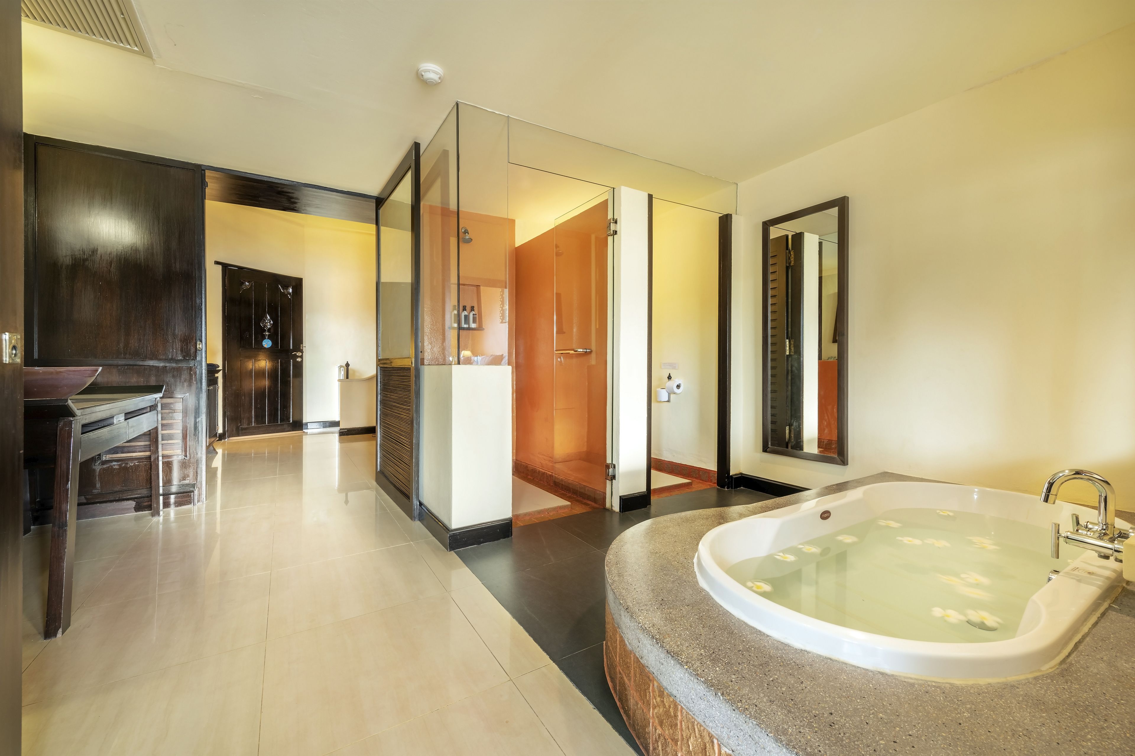 A modern bathroom with a large bathtub, a shower area, and a vanity with a mirror.