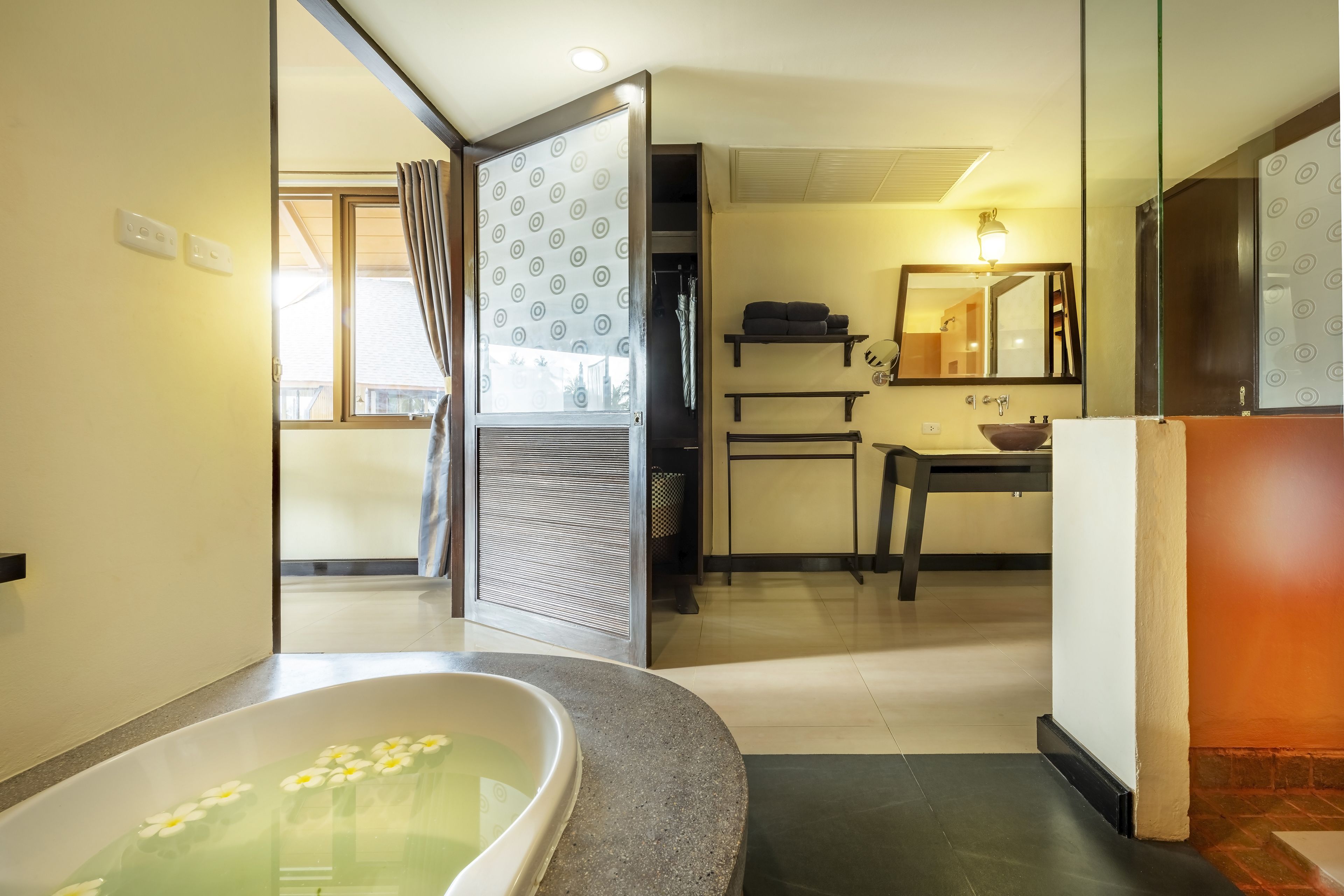 Ein modernes Badezimmer mit einer Badewanne, einem Spiegel und einem Waschbecken.