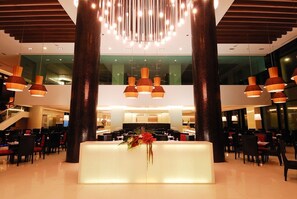 A spacious lobby with a reception desk, large pillars, and hanging pendant lights. - The Zign Hotel (Pattaya)