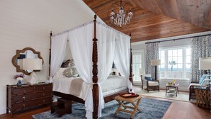 A bedroom with a four-poster bed, wooden ceiling, and a chandelier. - Port d'Hiver (Melbourne Beach)
