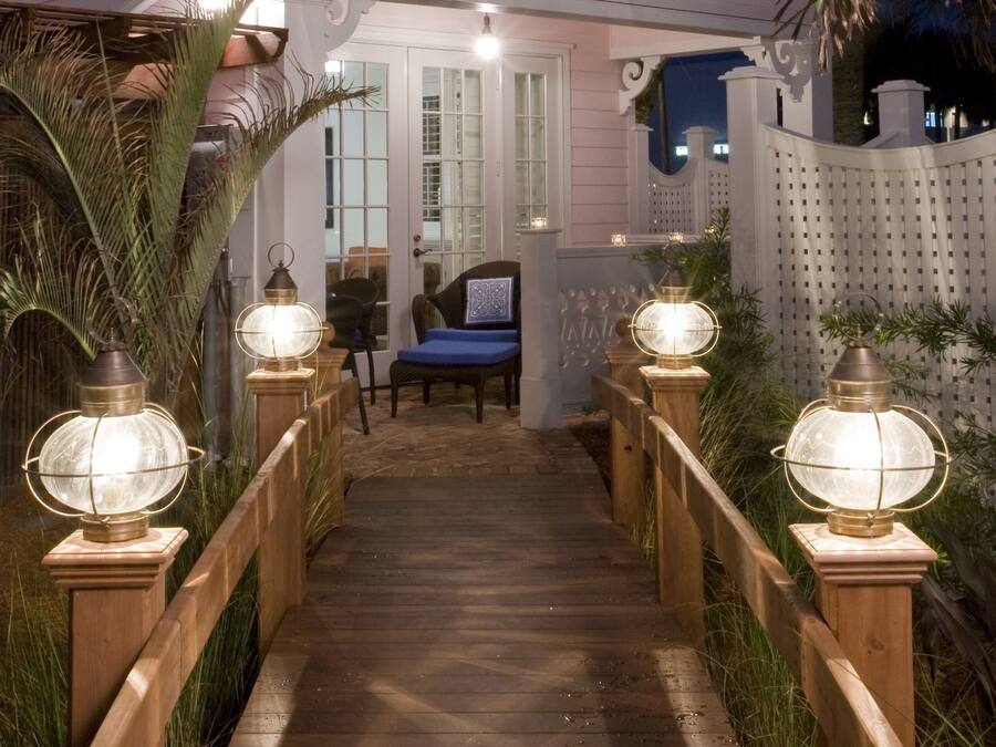 A wooden pathway leading to a room with a chair and a blue cushion.