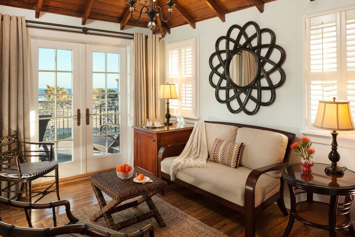 A cozy living room with a sofa, chairs, a coffee table, and a decorative wall piece.