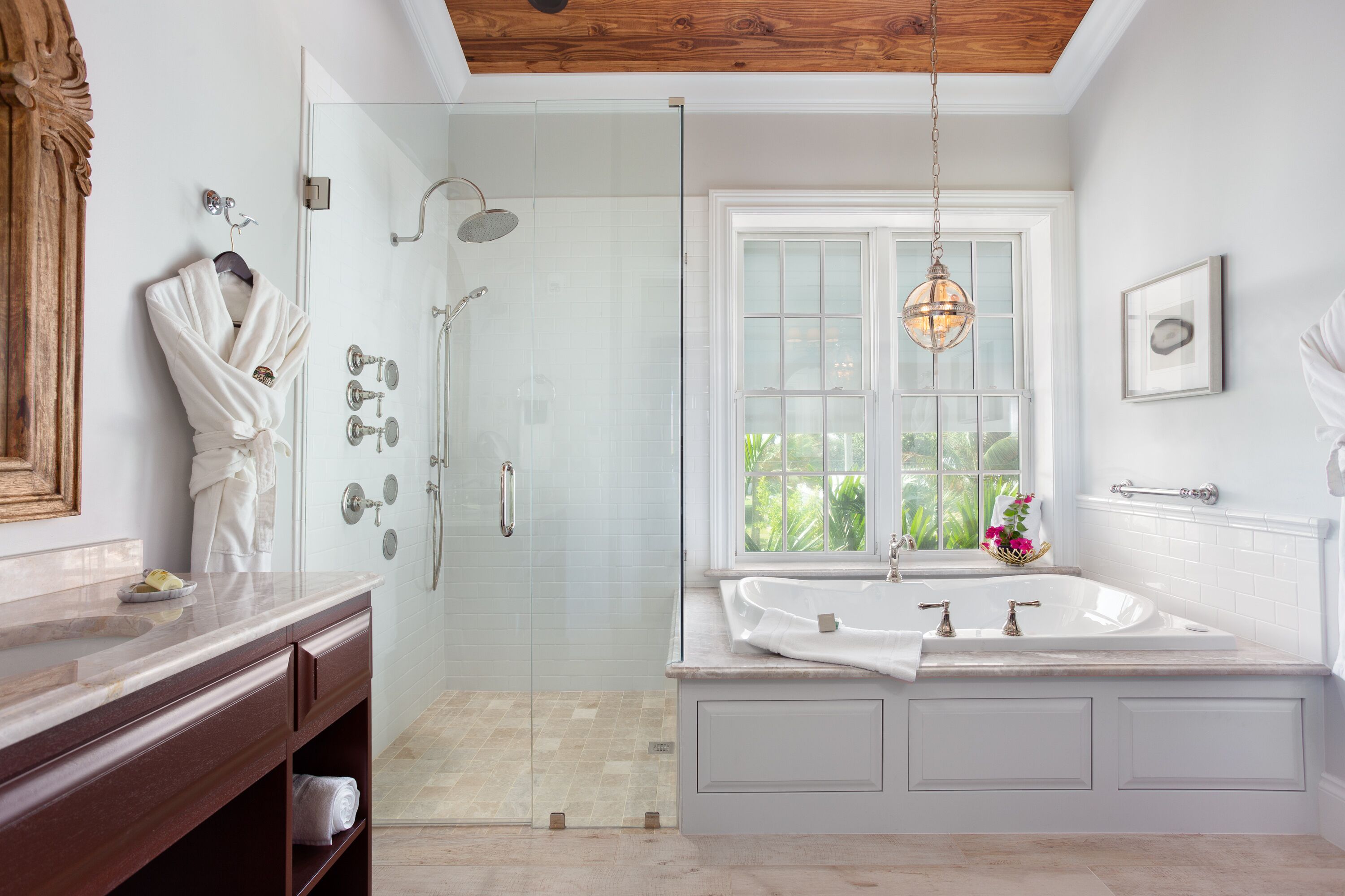 A modern bathroom with a walk-in shower, a large bathtub, and a vanity with a mirror.