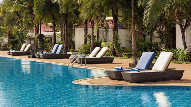 Un espace aménagé au bord de la piscine, avec des chaises longues et une piscine à l’eau d’un bleu limpide.