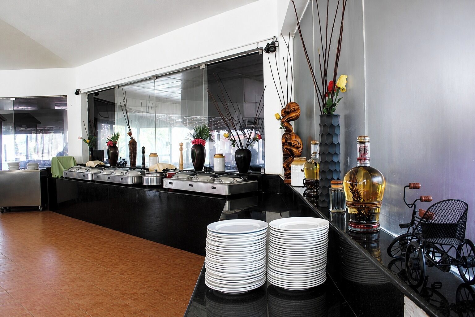 Una cocina moderna con separador de vidrio, electrodomésticos de acero inoxidable y diversos objetos decorativos.