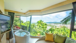 A modern room with a large bed, a massage chair, and a TV. - Andaman Cannacia Resort & Spa (Karon)