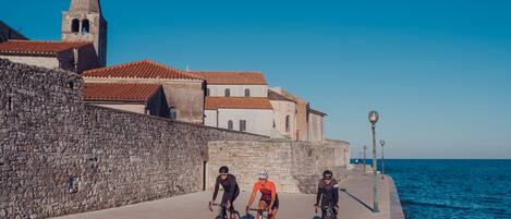A coastal promenade with stone walls and a church tower.