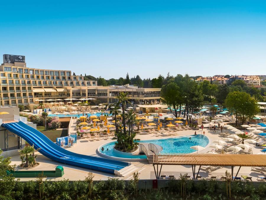 Una piscina al aire libre de temporada, sombrillas