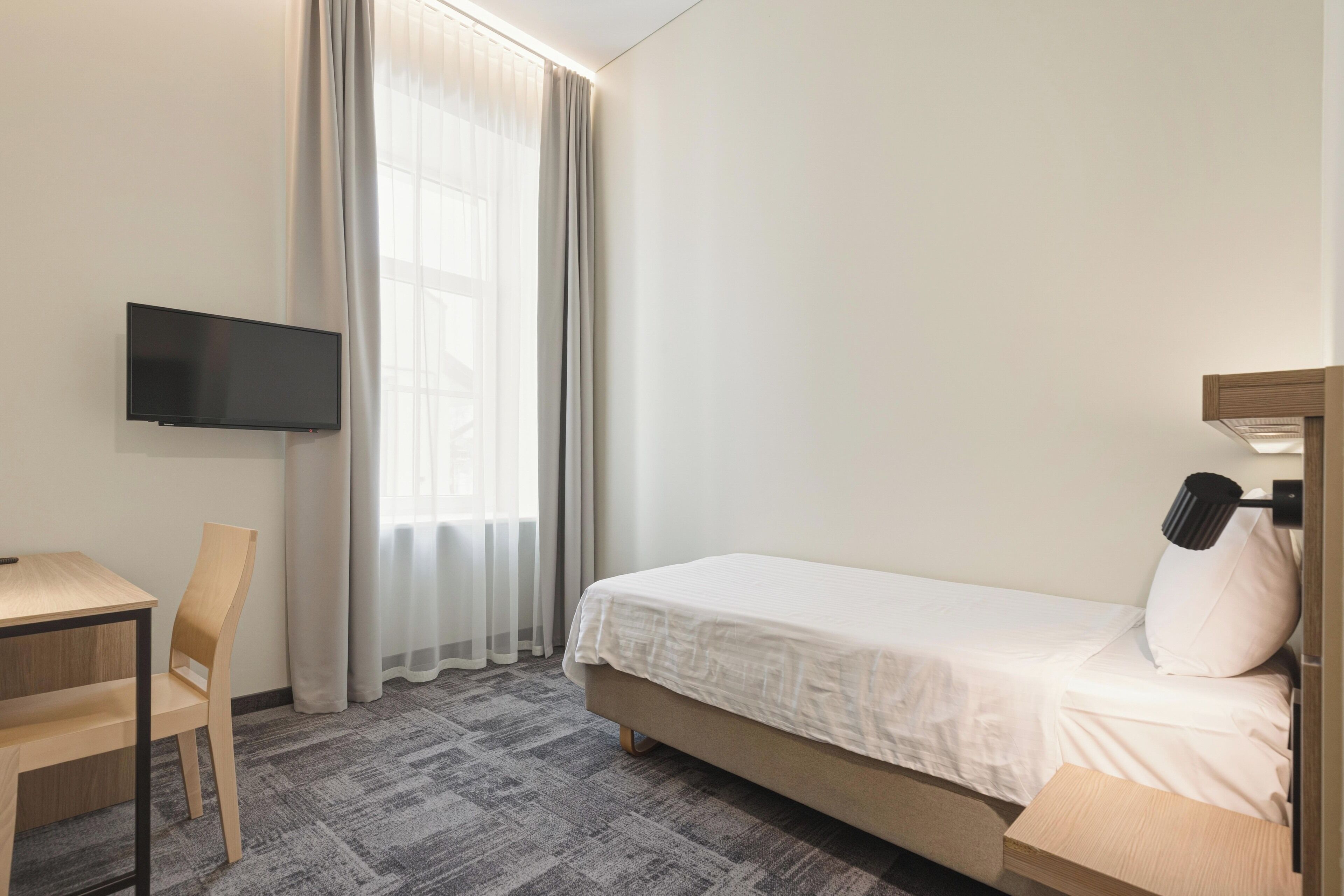 Modern Single Room | Minibar, caja fuerte, escritorio y cortinas opacas