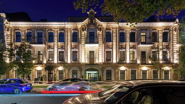 Un edificio histórico con fachada simétrica, ventanas amplias y una entrada central.
