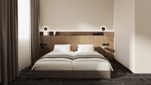 Una habitación de hotel moderna con una cama grande, cabecera de madera y una mesita de noche con lámpara.