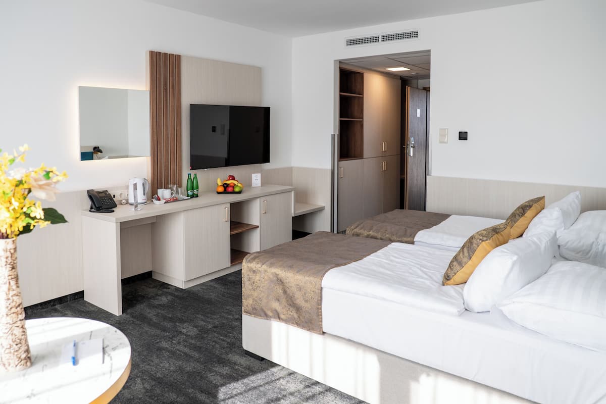 Una habitación de hotel con cama, escritorio y televisión.