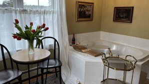 A bathroom with a bathtub, a vanity, and a chandelier. - Surfside Inn (Queensland)