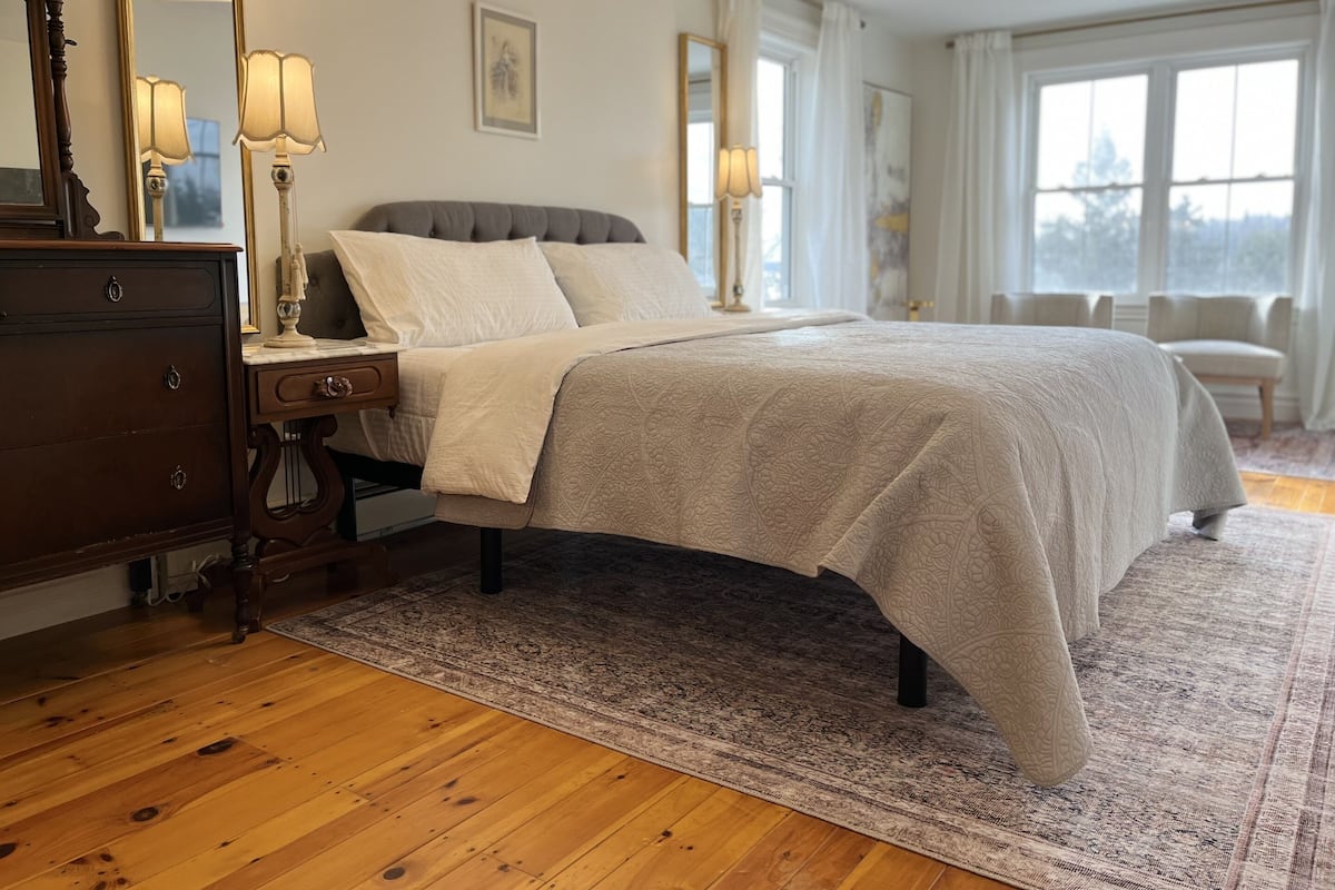 A bedroom with a bed, dresser, and bedside lamps.