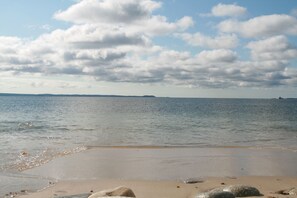 A beach with a clear sky and calm water.