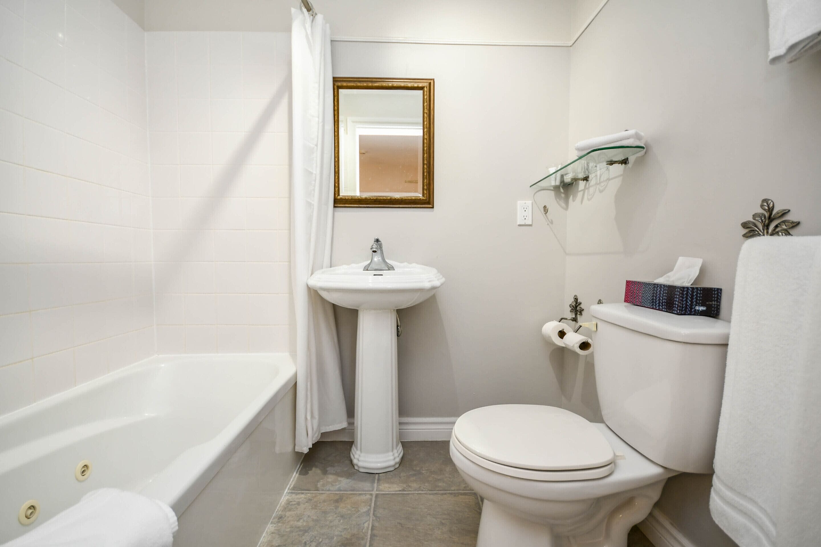 Ein Badezimmer mit Badewanne, Waschbecken, Toilette und Spiegel.