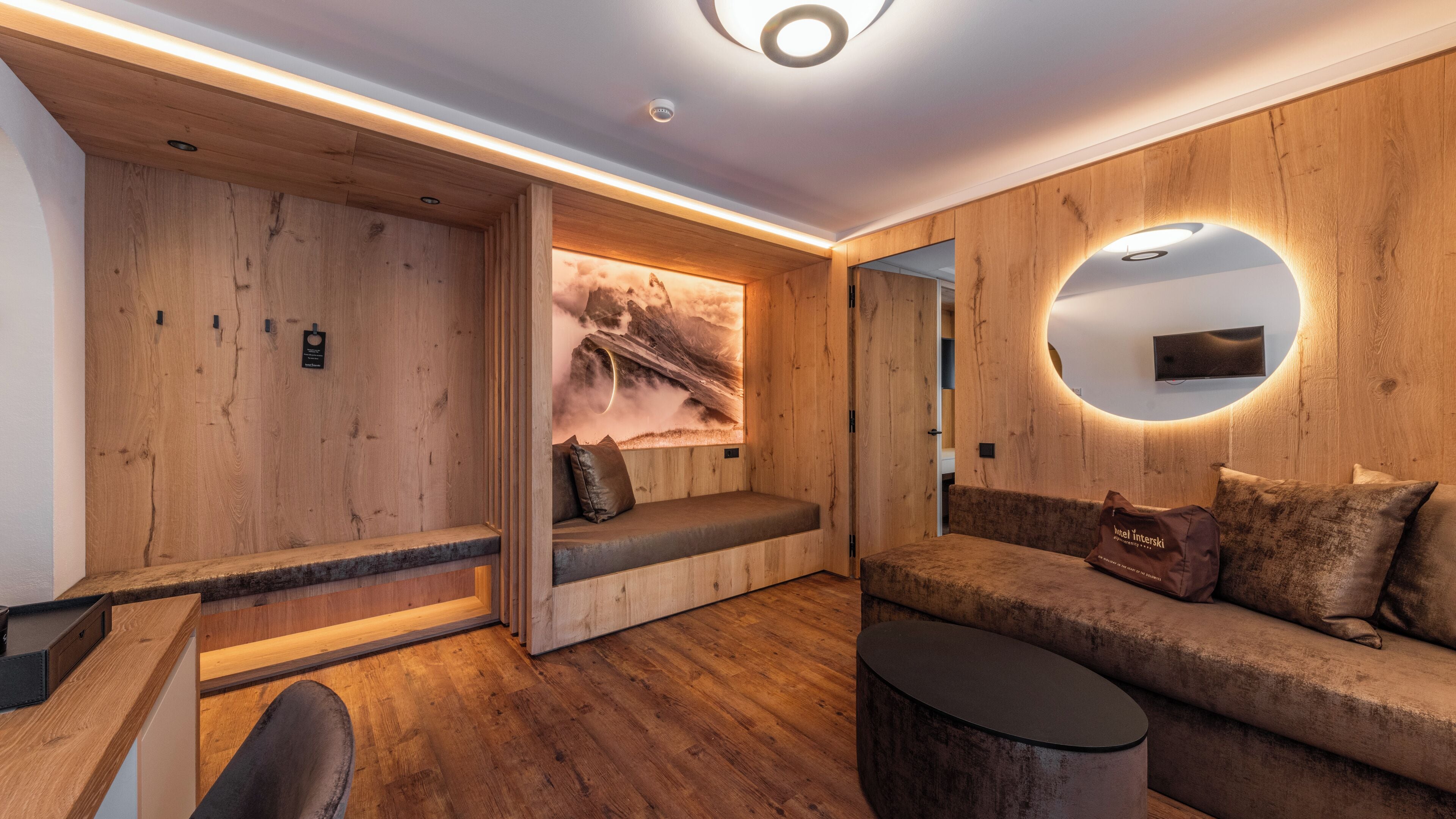 Ein modernes Interieur mit Holzvertäfelung, einer gemütlichen Sitzecke und einem an der Wand befestigten Fernseher.