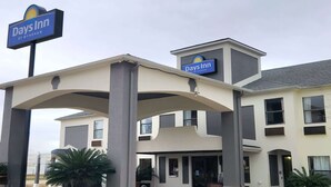 Edificio di un Days Inn by Wyndham con un cartello ben visibile, un ingresso coperto e un design architettonico moderno.