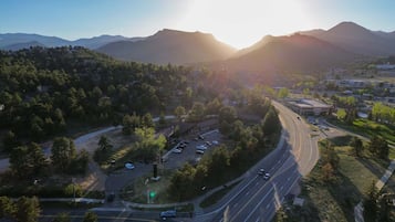 A highway with multiple lanes and vehicles, surrounded by trees and a mountainous landscape.