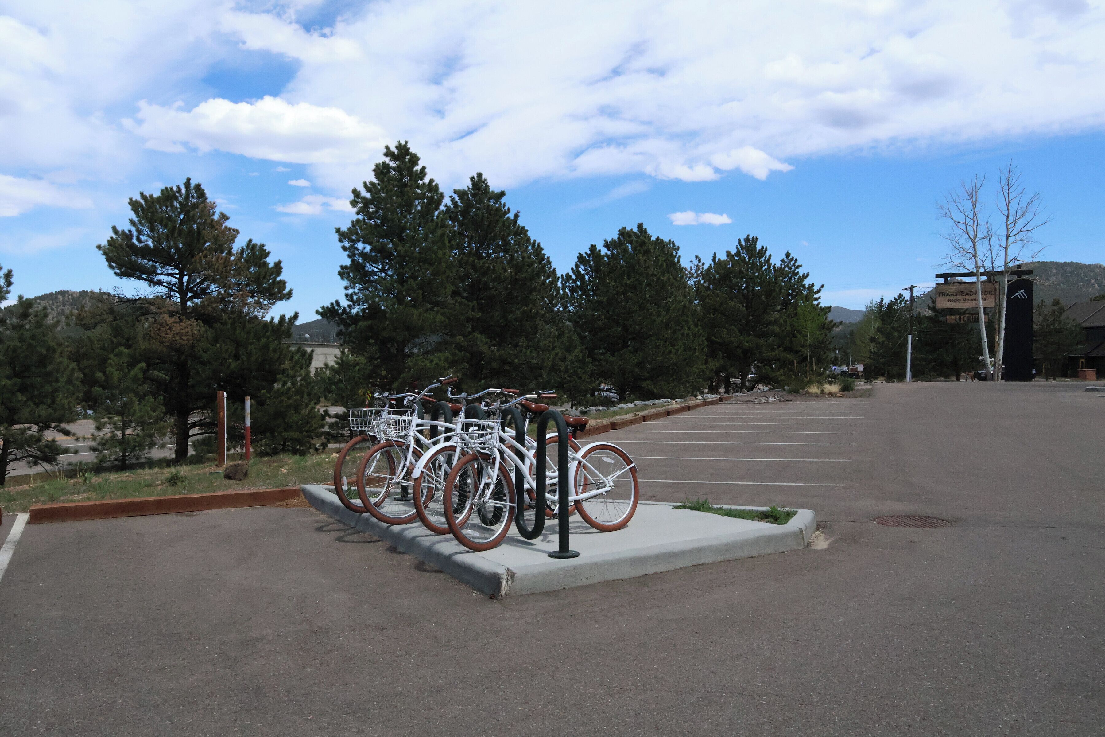 A parking lot with bicycles parked in a designated area.