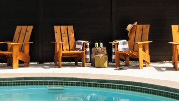 Una piscina al aire libre de temporada, tumbonas