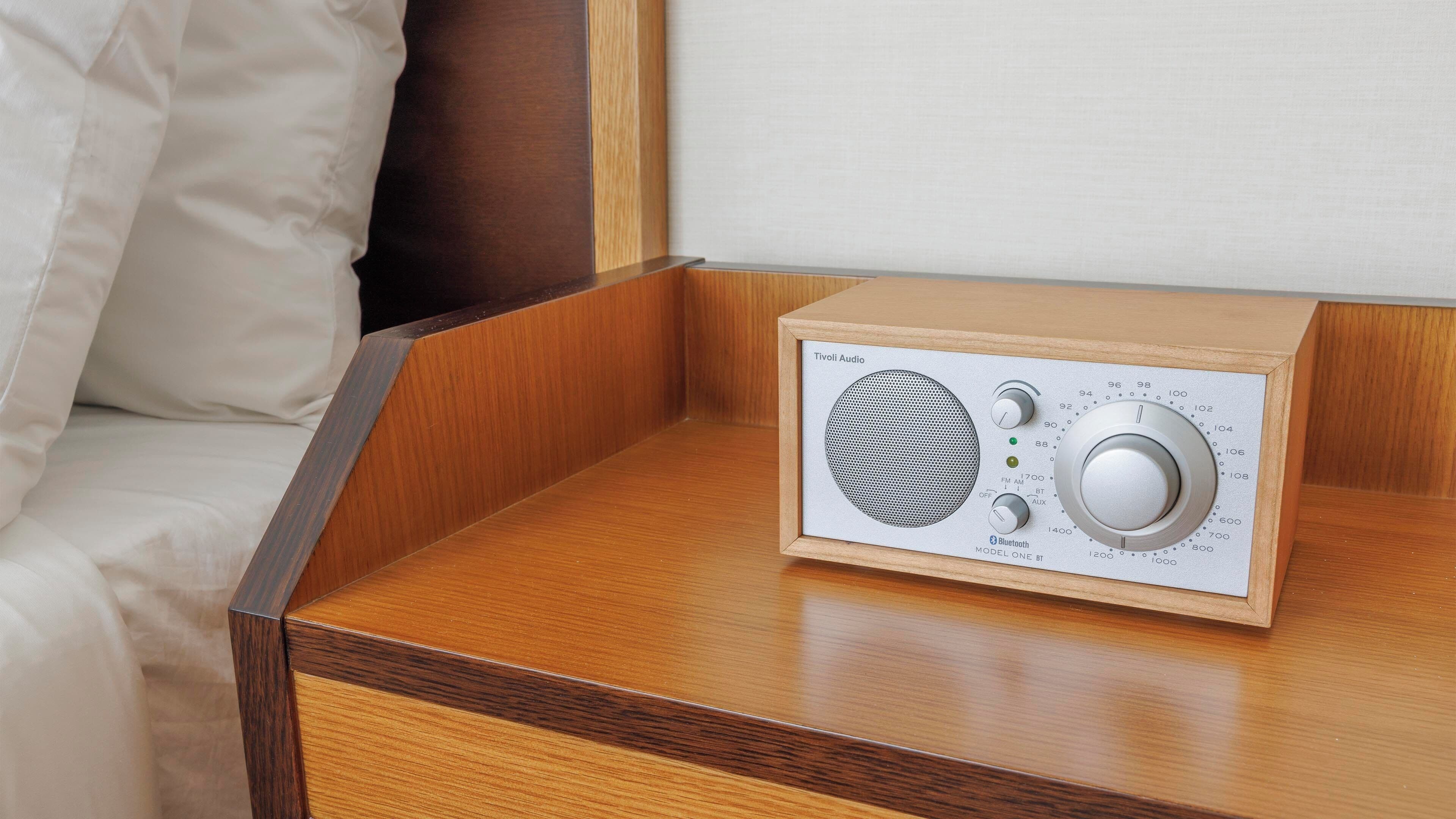 A wooden bedside table with a radio on it.