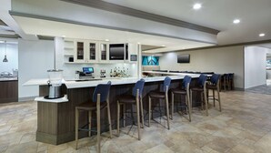 Une cuisine moderne dotée d’un coin bar, équipée d’une machine à café, d’une balance numérique et d’un réfrigérateur à vin.