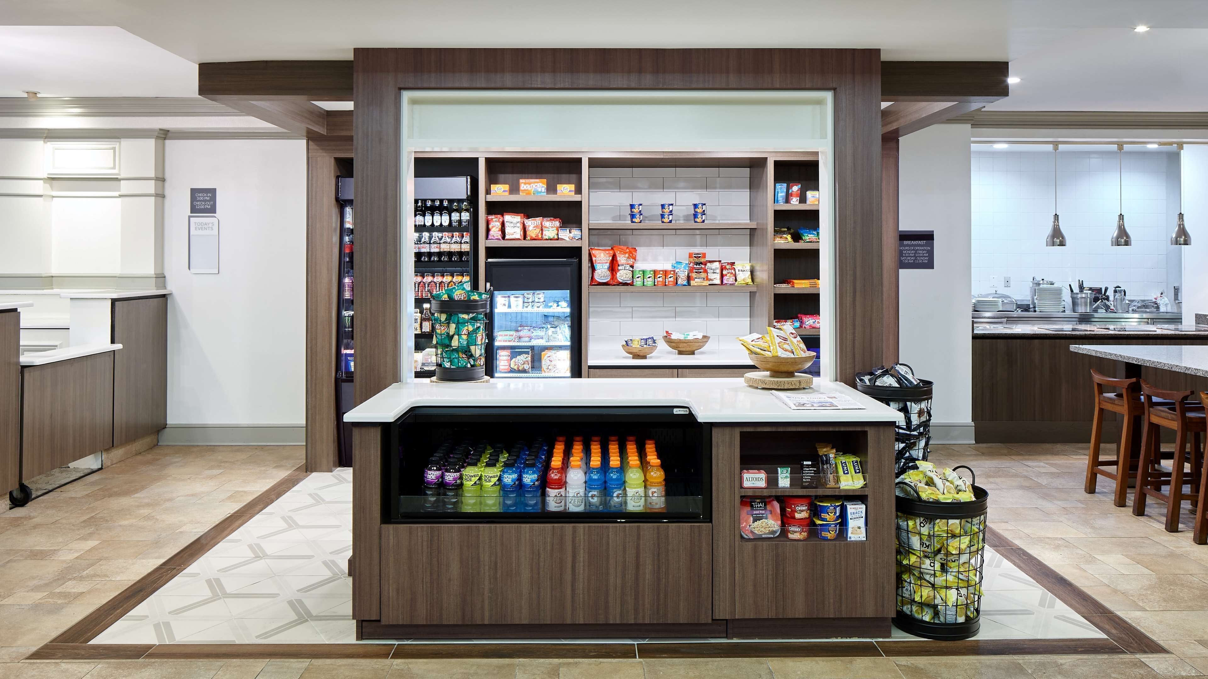 A modern kitchen with a built-in beverage dispenser, a coffee machine, and a variety of snacks and condiments.