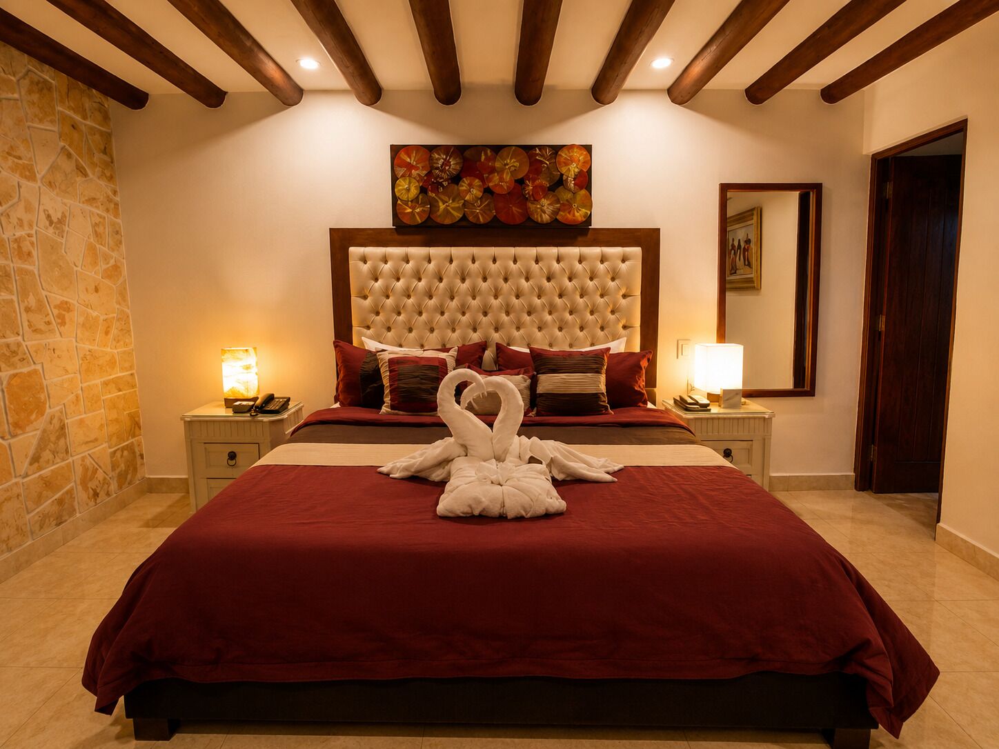 Una habitación de hotel con una cama grande, una pared de piedra y un techo de madera.