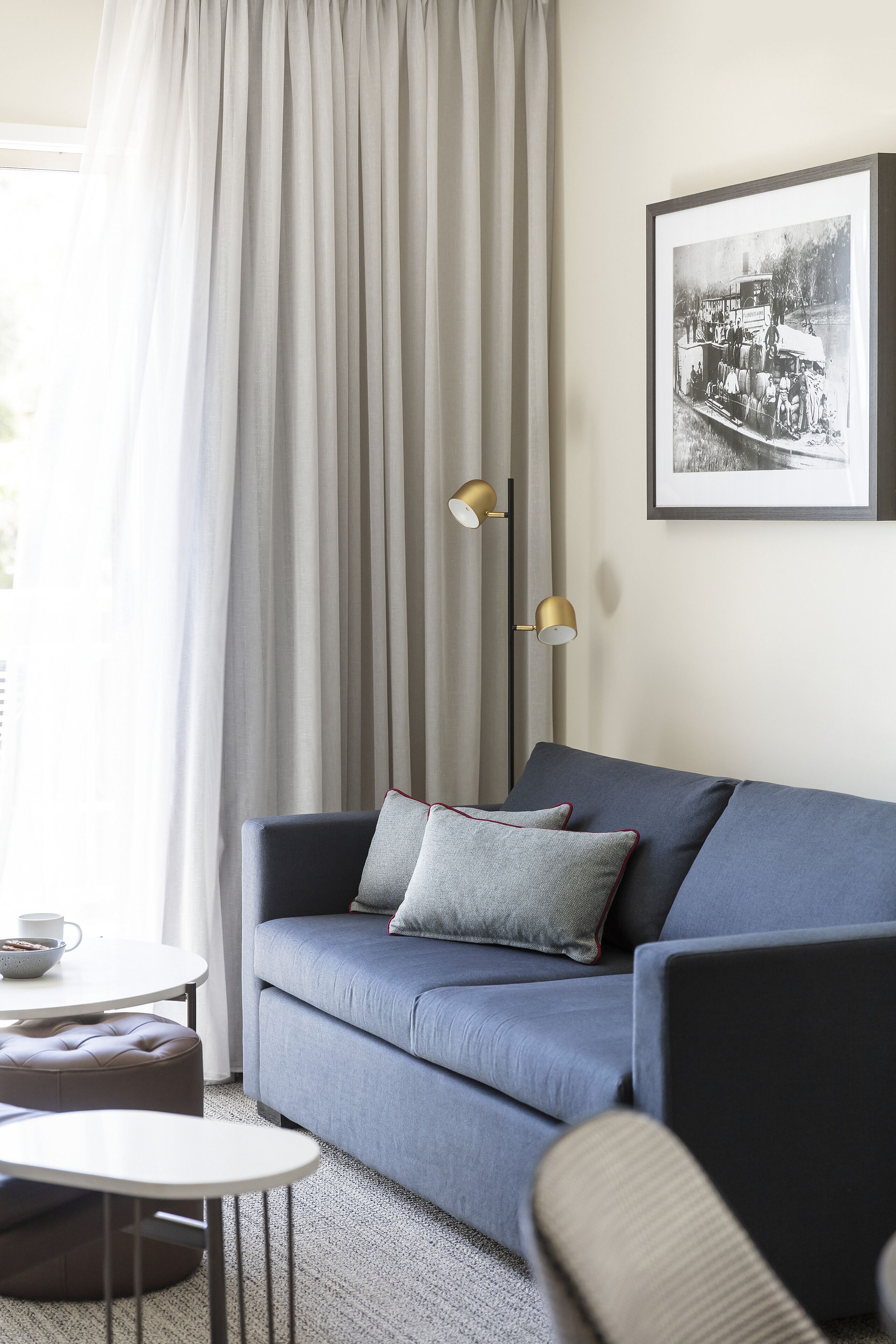 A modern living room with a blue sofa, a round coffee table, and a lamp.