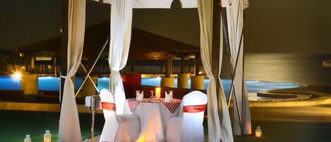 Decoração de casamento ao ar livre com toldo, mesas, cadeiras e tapete vermelho.
