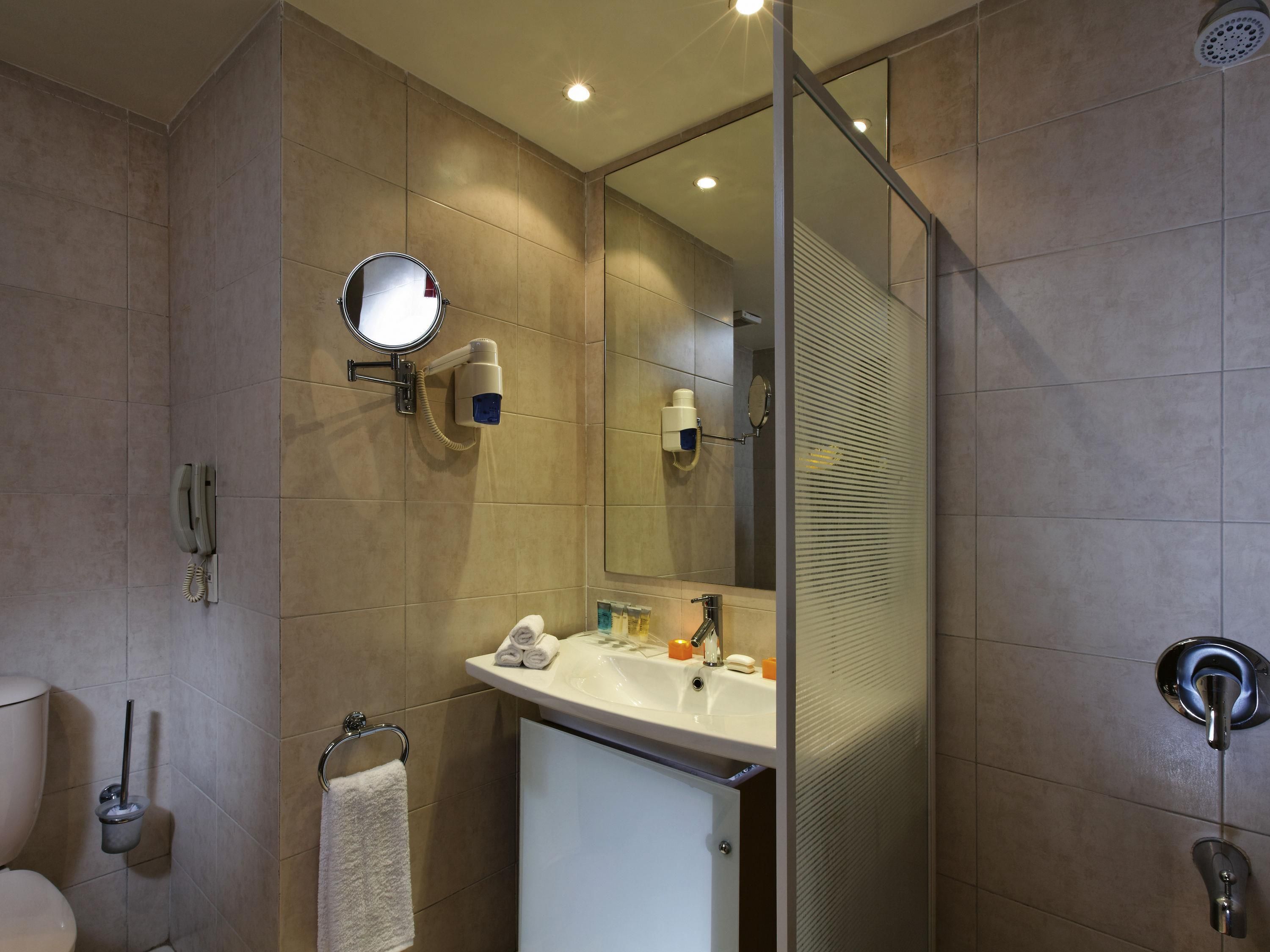 A modern bathroom with a toilet, sink, and shower area.