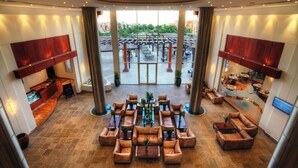 A spacious lobby with a central seating area, large windows, and a view of the outdoor area. - Mövenpick Resort El Sokhna (Ataqah)
