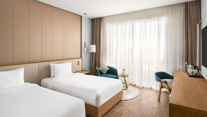 A hotel room with two beds, a desk, a chair, a lamp, and a large window with curtains. - Mövenpick Resort El Sokhna (Ataqah)