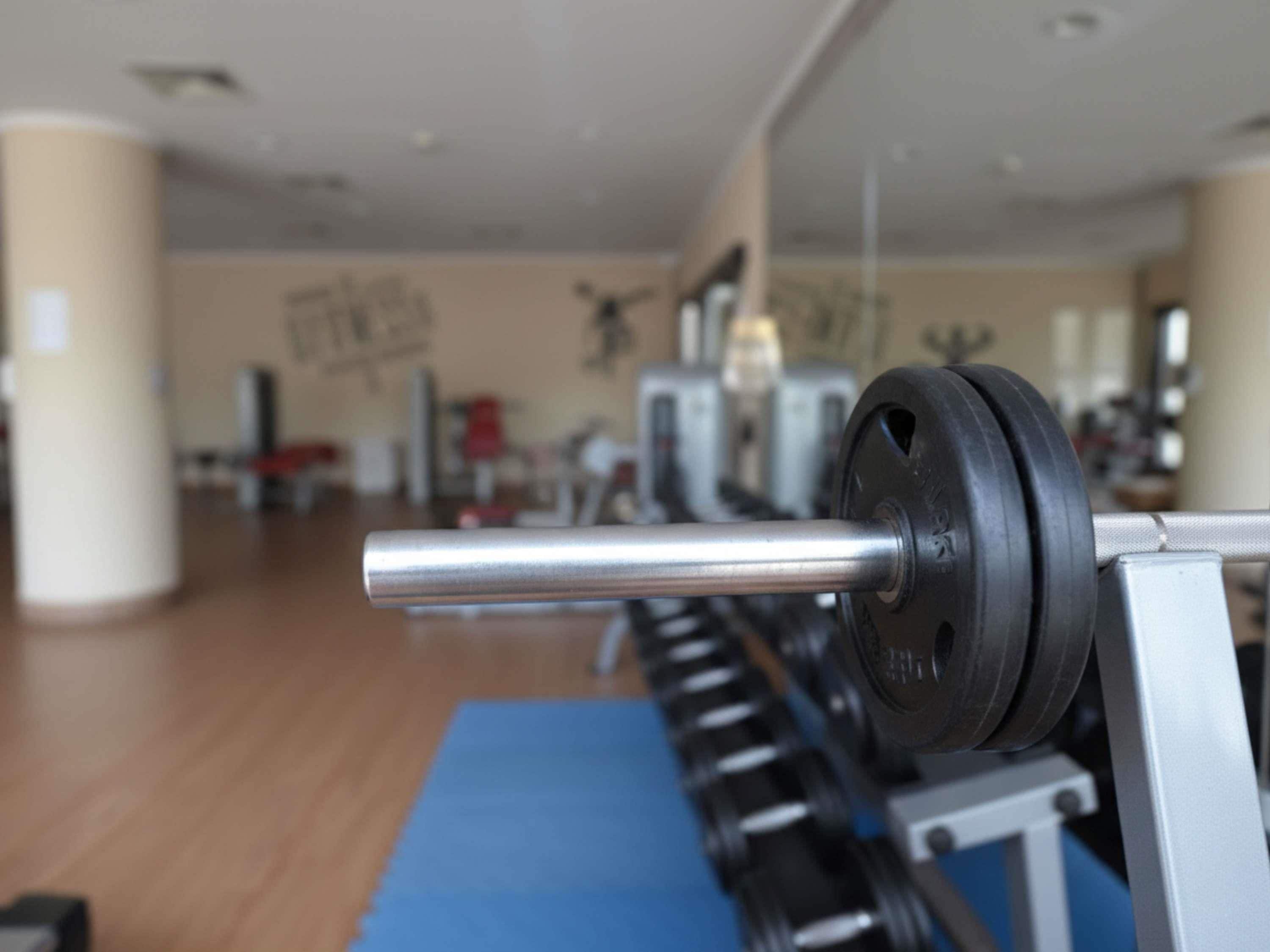 Une salle de sport équipée d’un banc de musculation et d’une barre d’haltères.