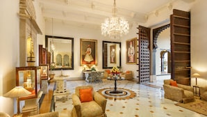 A spacious lobby with ornate chandeliers, a grand staircase, and traditional decor. - Shiv Niwas Palace by HRH Group of Hotels (Udaipur)