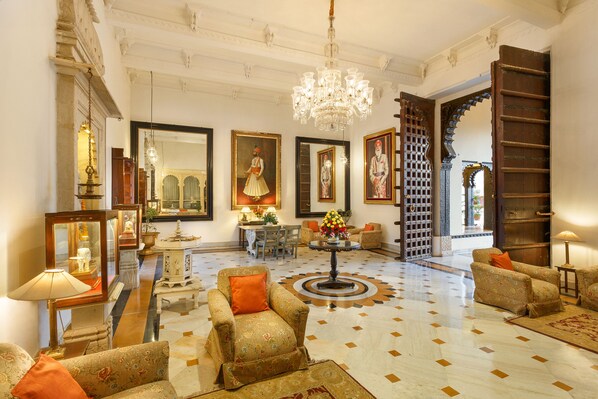 A spacious lobby with ornate chandeliers, a grand staircase, and traditional decor. - Shiv Niwas Palace by HRH Group of Hotels (Udaipur)