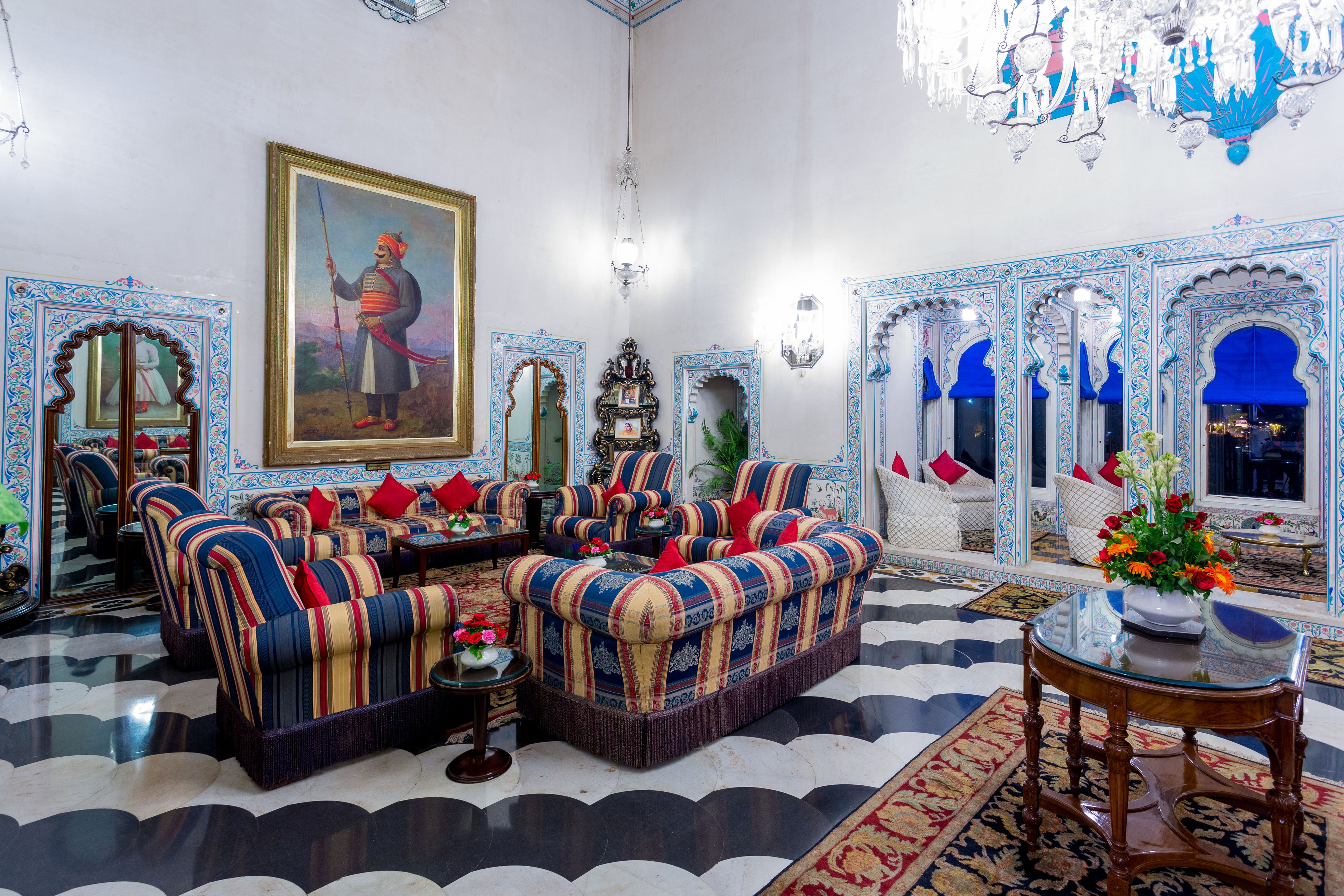 Ein traditionelles Interieur mit Sofas, einer Kristalllüster und einem großen, gerahmten Gemälde.