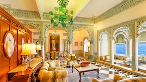 A luxurious lobby with ornate green and gold decor, a grand chandelier, and a view of the sea. - Shiv Niwas Palace by HRH Group of Hotels (Udaipur)